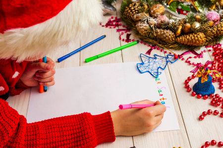 193389665-il-ragazzo-carino-con-il-cappello-di-babbo-natale-scrive-una-lettera-a-babbo-natale