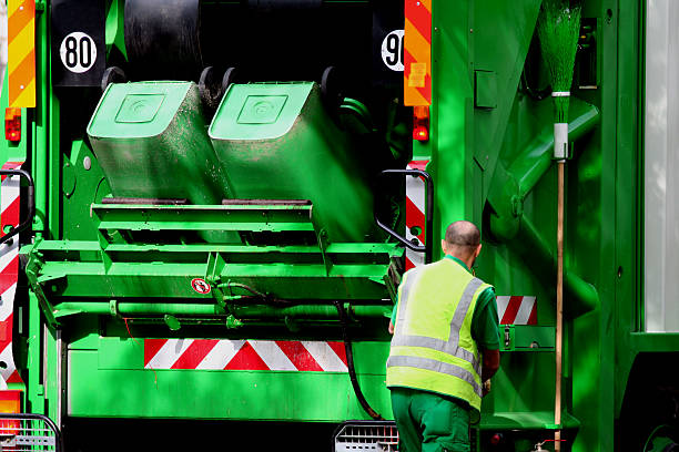 Addetto alla raccolta rifiuti con camion raccolta rifiuti verde