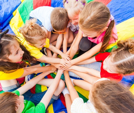 Gruppo di bambini in cerchi con le mani unite nel centro
