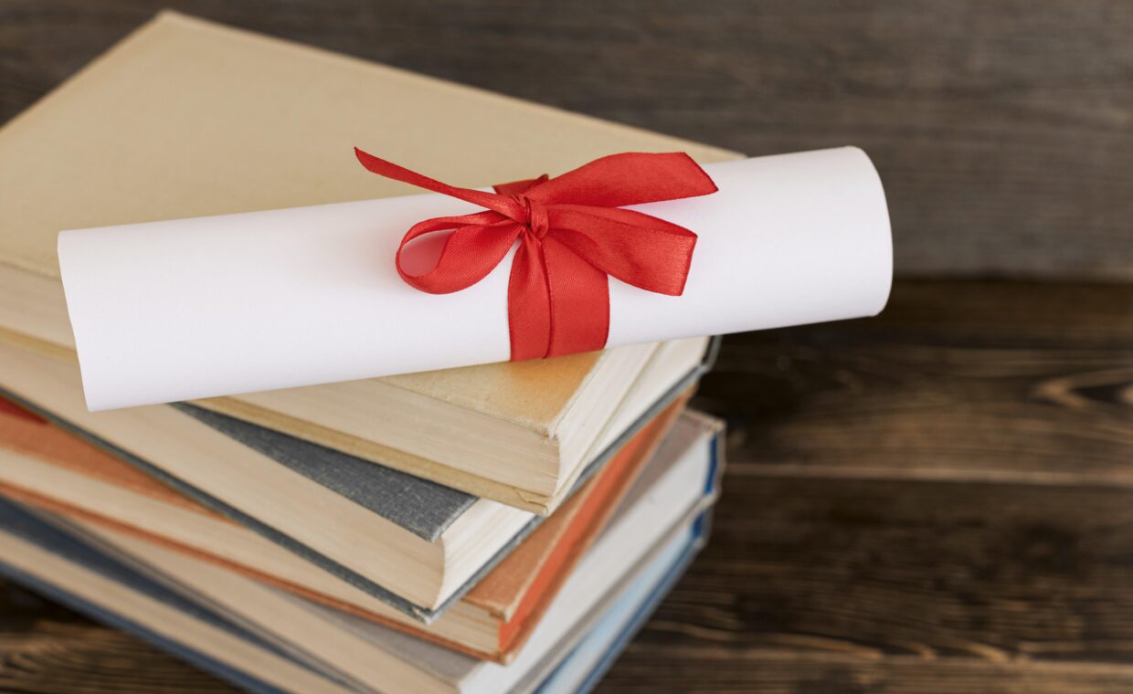 Immagine di alcuni libri e una pergamena di laurea