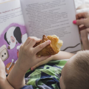 Immagine di un bambino in braccio a una donna che gli legge un libro