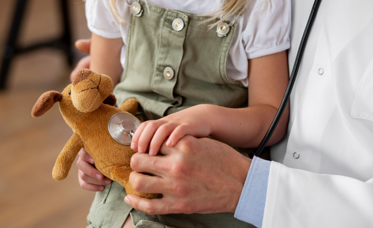 Foto di un medico che visita il peluche di una bambina