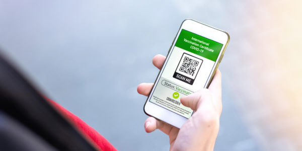 male-hand-holding-a-smartphone-with-international-vaccination-certificate-covid19-qr-code