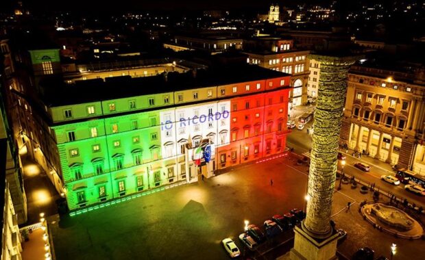Foto di Palazzo Chigi illuminato con il tricolore e la scritta "io ricordo"