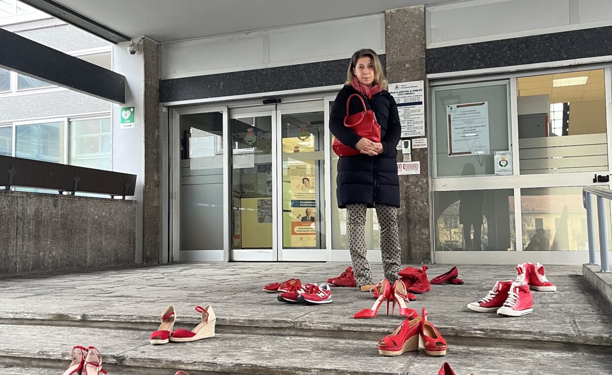 Foto del Vice Sindaco Travagliati e dell'installazione Scarpe Rosse in Municipio