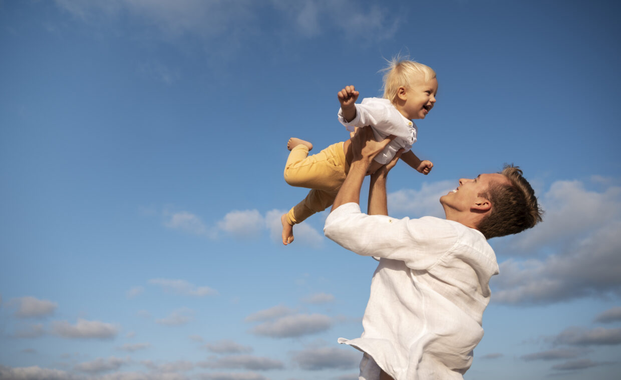 Foto di un papà che prende in braccio sua figlia