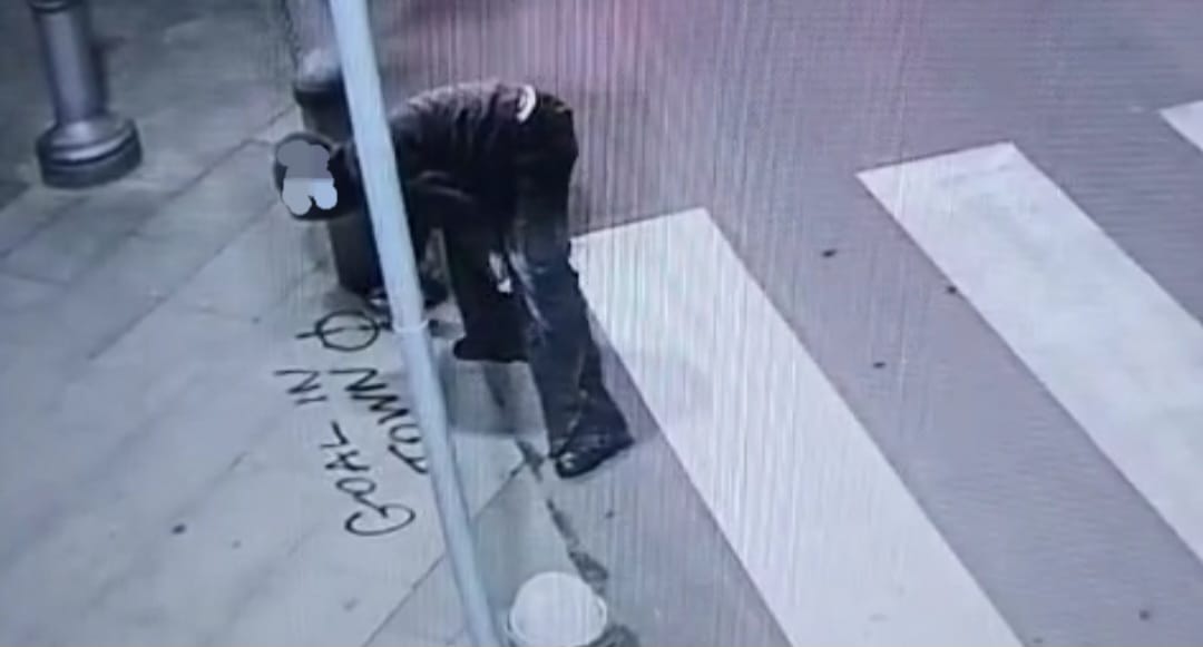 Fermoimmagine del giovane intento ad imbrattare
