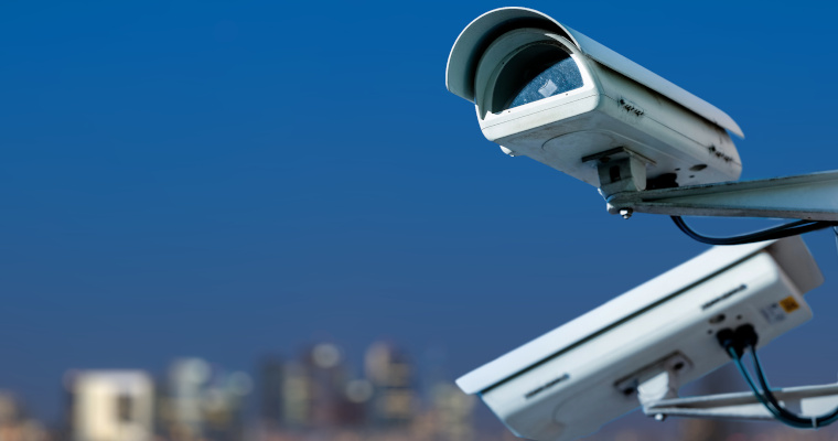 security CCTV camera monitoring system with panoramic view of a city on blurry background