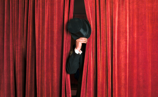 Mano attore con cilindro che esce da sipario