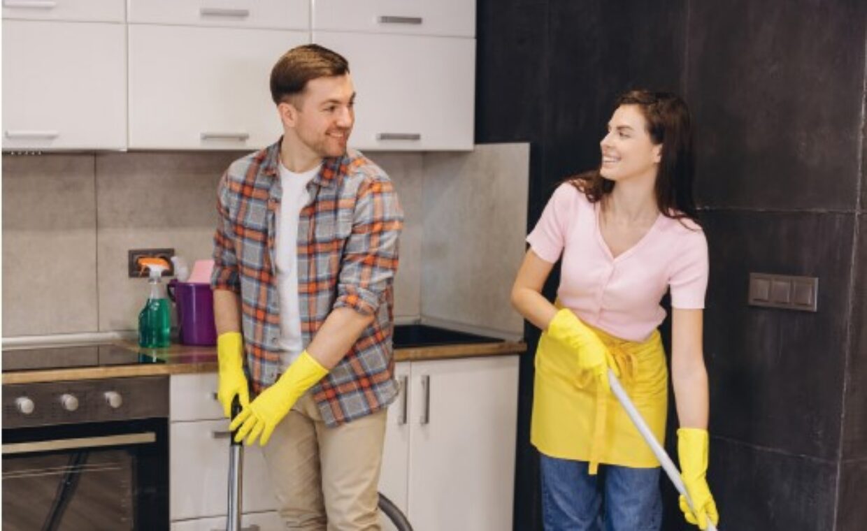 Foto generica di un uomo e una donna impegnati in lavori di pulizia della casa