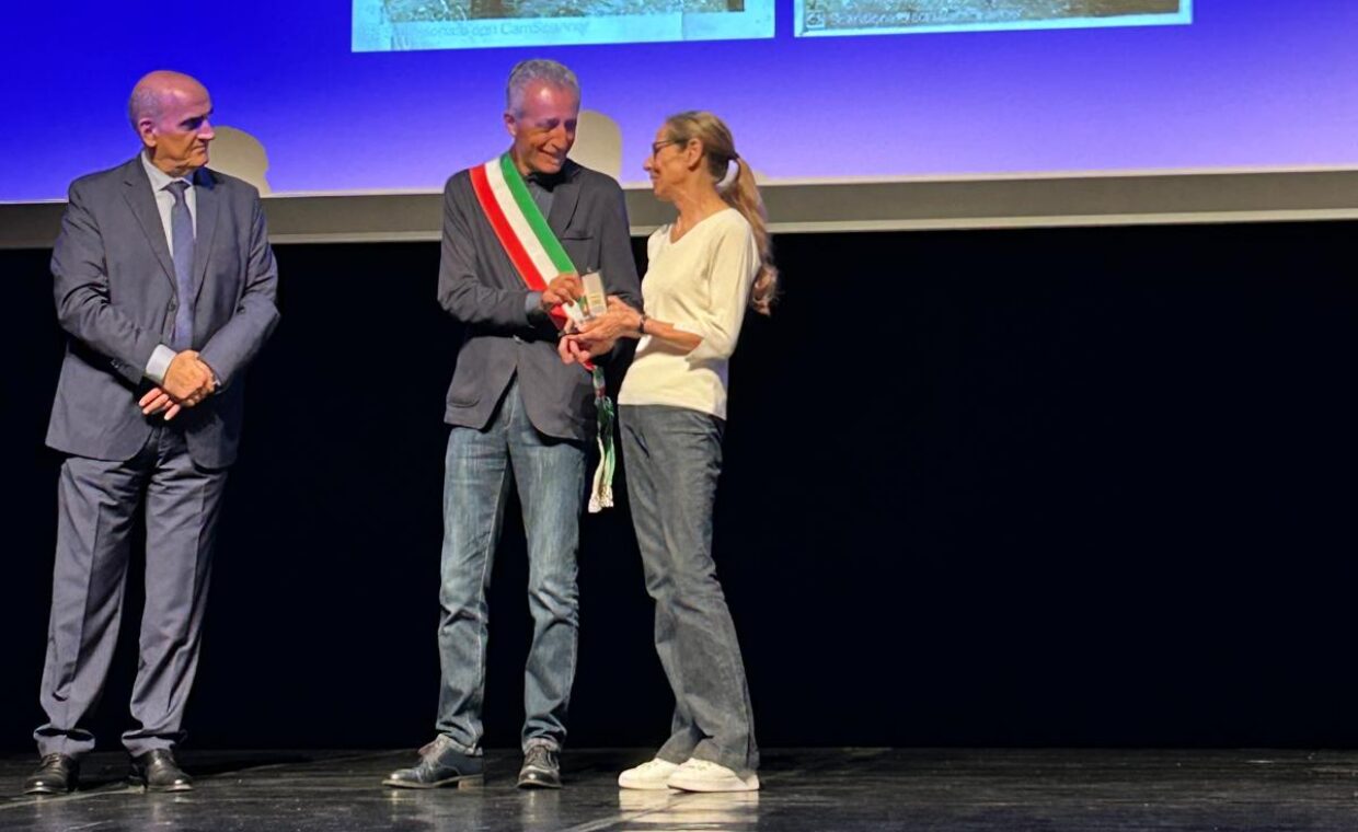 Il sindaco Pietro Giovanni Cicardi consegna ad Angela Galbiati la medaglia d'onore alla memoria del padre Antonio Galbiati sul palco del teatro 7 a Monza affiancato dal prefetto di Monza Enrico Roccatagliata