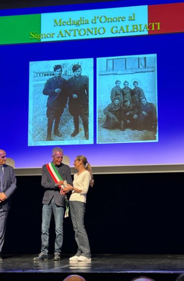 Il sindaco Pietro Giovanni Cicardi consegna ad Angela Galbiati la medaglia d'onore alla memoria del padre Antonio Galbiati sul palco del teatro 7 a Monza affiancato dal prefetto di Monza Enrico Roccatagliata